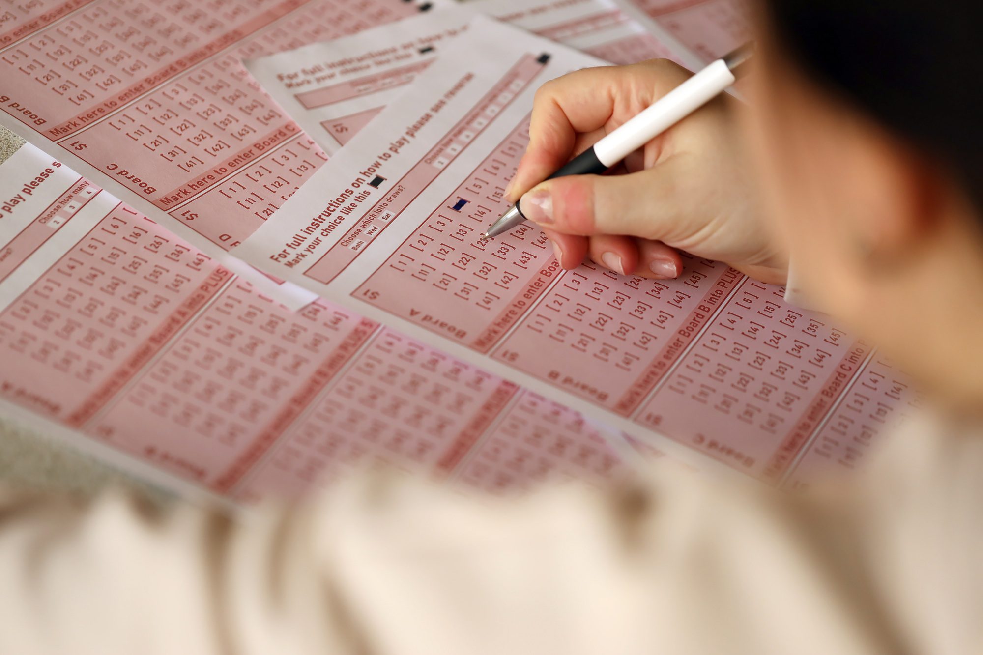 Filling out a lottery ticket. A young woman plays the lottery and dreams of winning the jackpot